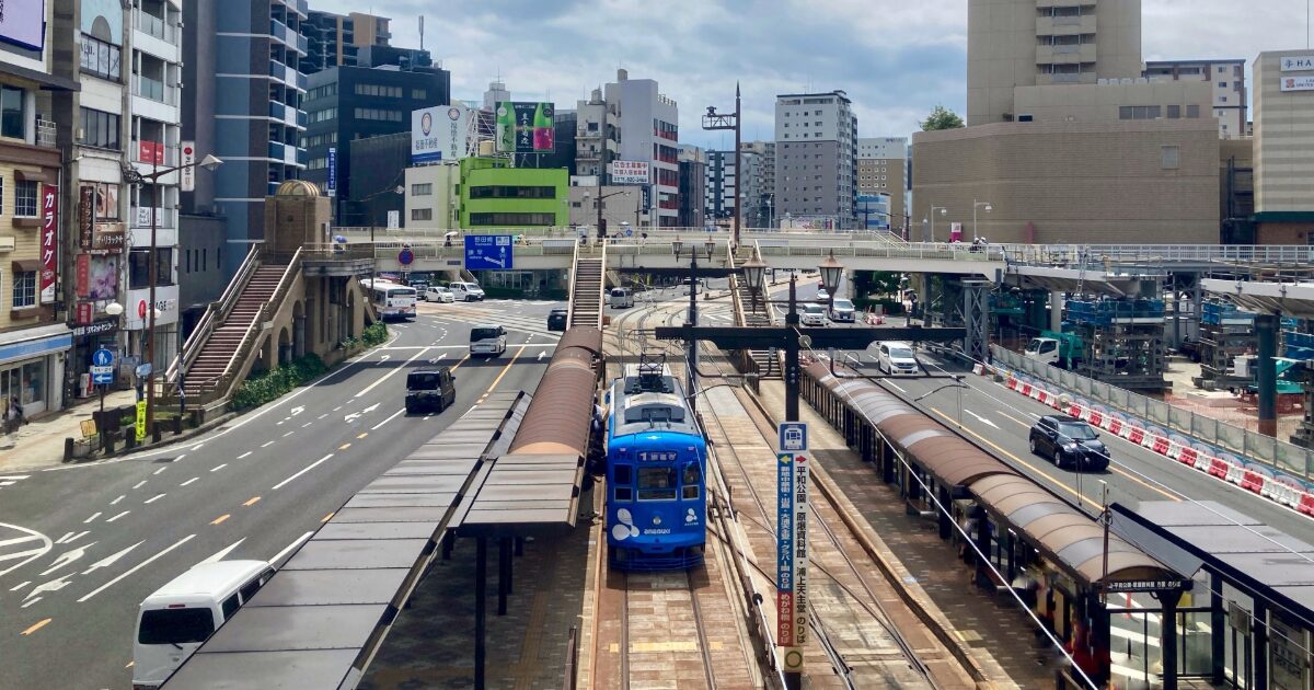 長崎市内を走る路面電車と停留所の街並み