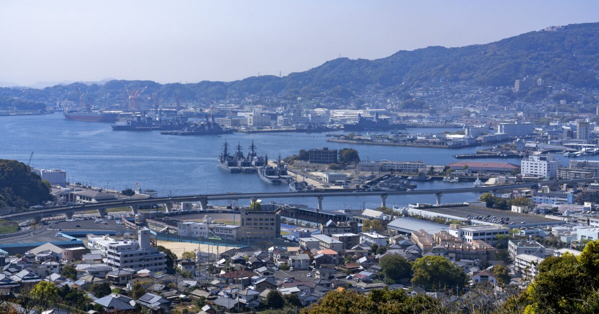 佐世保港に停泊する自衛艦と造船所を望む都市景観